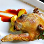 Galletto arrosto intero con patate, in un piatto bianco